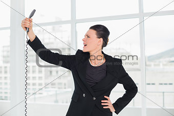 Elegant young businesswoman shouting into the phone