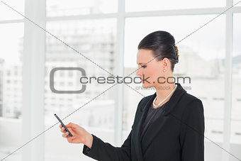 Elegant businesswoman looking at cellphone