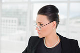 Elegant businesswoman in eyeglasses looking away