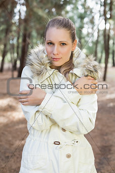Cute woman shivering while having a walk in a forest