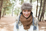 Woman wearing fur hat with woolen scarf and jacket in woods