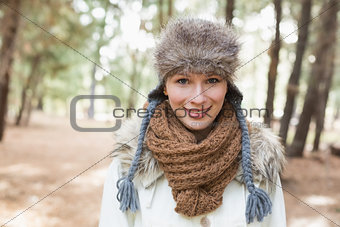 Woman wearing fur hat with woolen scarf and jacket in woods