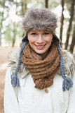 Beautiful woman wearing fur hat with woolen scarf and jacket in woods