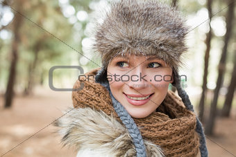 Woman in fur hat with woolen scarf in the woods