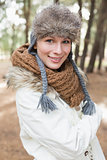 Woman in fur hat with woolen scarf and jacket in the woods