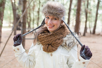 Woman in fur hat with woolen scarf and jacket in the woods
