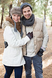 Cheerful couple in winter clothing in the woods