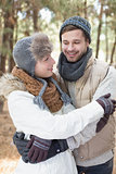 Couple in winter clothing embracing in the woods