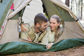 Loving couple lying in tent after a hike