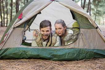 Happy couple lying in tent after a hike