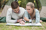 Young couple reading map in tent