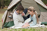 Young couple with a map lying in tent