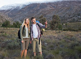 Fit young couple with backpacks on landscape