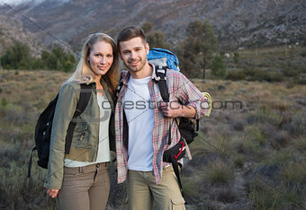 Couple with backpacks standing on forest landscape