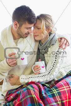 Loving couple in winter clothing with coffee cups