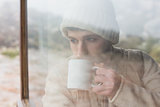 Man drinking coffee seen through cabin window