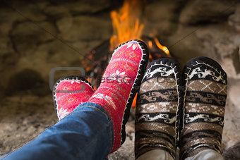 Close up of romantic legs in socks in front of fireplace