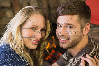 Romantic couple smiling in front of fireplace