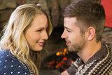 Romantic couple smiling in front of fireplace