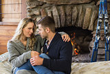 Young couple in front of lit fireplace