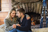 Romantic couple in front of lit fireplace