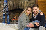 Portrait of a romantic couple in front of lit fireplace