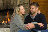 Lovely couple in front of lit fireplace