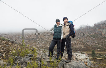 Couple standing on rock after a trek against clear sky