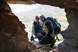 Couple seen through rock cave while on a hike