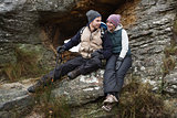 Smiling couple sitting on rock while on a hike