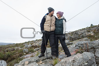 Couple standing on rocky landscape against the sky
