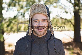 Close up of a smiling man in warm clothing in forest