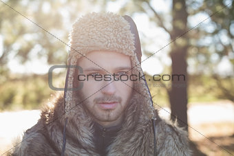 Close up of a handsome man in warm clothing in forest