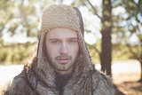 Close up of a handsome man in warm clothing in forest