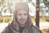 Close up portrait of a smiling man in warm clothing in forest