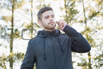 Serious man using mobile phone outdoors