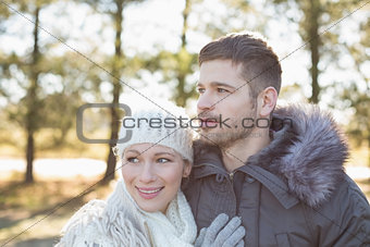 Smiling couple in winter clothing in the woods