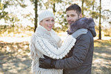 Loving young couple in winter clothing in the woods