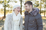 Cheerful couple in winter clothing in the woods