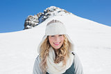 Smiling woman in front of snowed hill and clear blue sky
