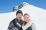 Couple in front of snowed hill and clear blue sky