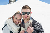 Smiling couple in front of snowed hill