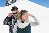 Couple in warm clothing against snowed hill