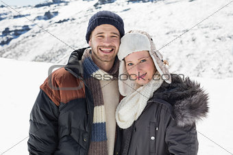 Couple in warm clothing standing on snowed landscape