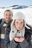 Couple with cupped hands on snowed landscape