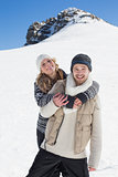 Couple in warm clothing against snowed hill