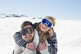 Cheerful couple in ski goggles on snow