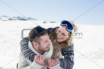 Close up of a cheerful couple with ski goggles on snow