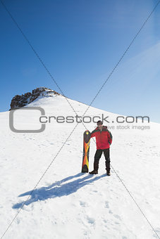 Man with ski board on snow covered landscape