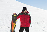 Man with ski board looking away on snow